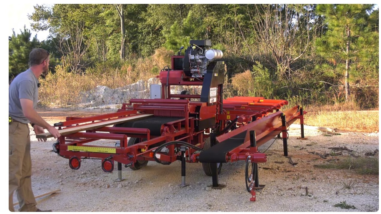 Cook’s Board Edger Transfer Deck shown in a complete sawmill setup, transferring boards automatically from the edger to the off-load area. Heavy-duty steel frame, powered rollers, and return deck design for one-man sawmill operation. Built in the USA by Cook’s Saw.