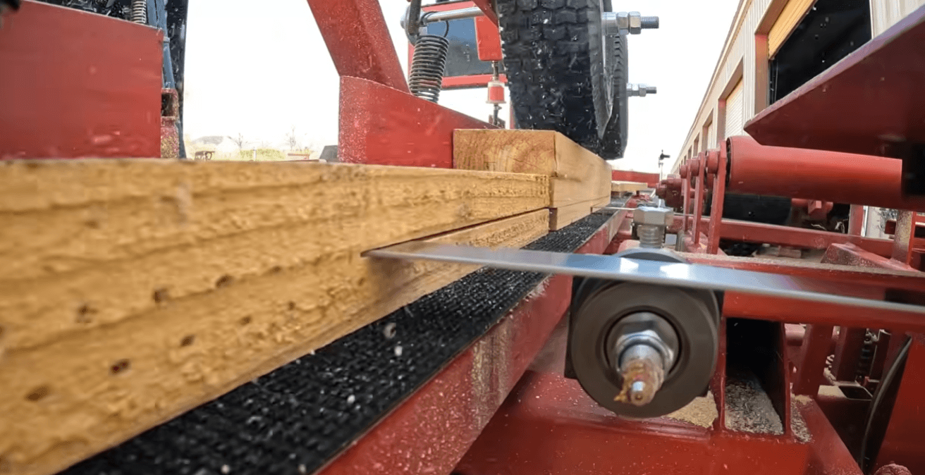 Close up of pallet resaw bandsaw blades cutting wood boards, double head resaw system designed for pallet production and industrial sawmill performance